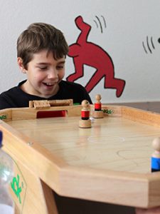 Ein Schüler freut sich beim einem Spiel im Raum der Schulsozialarbeit